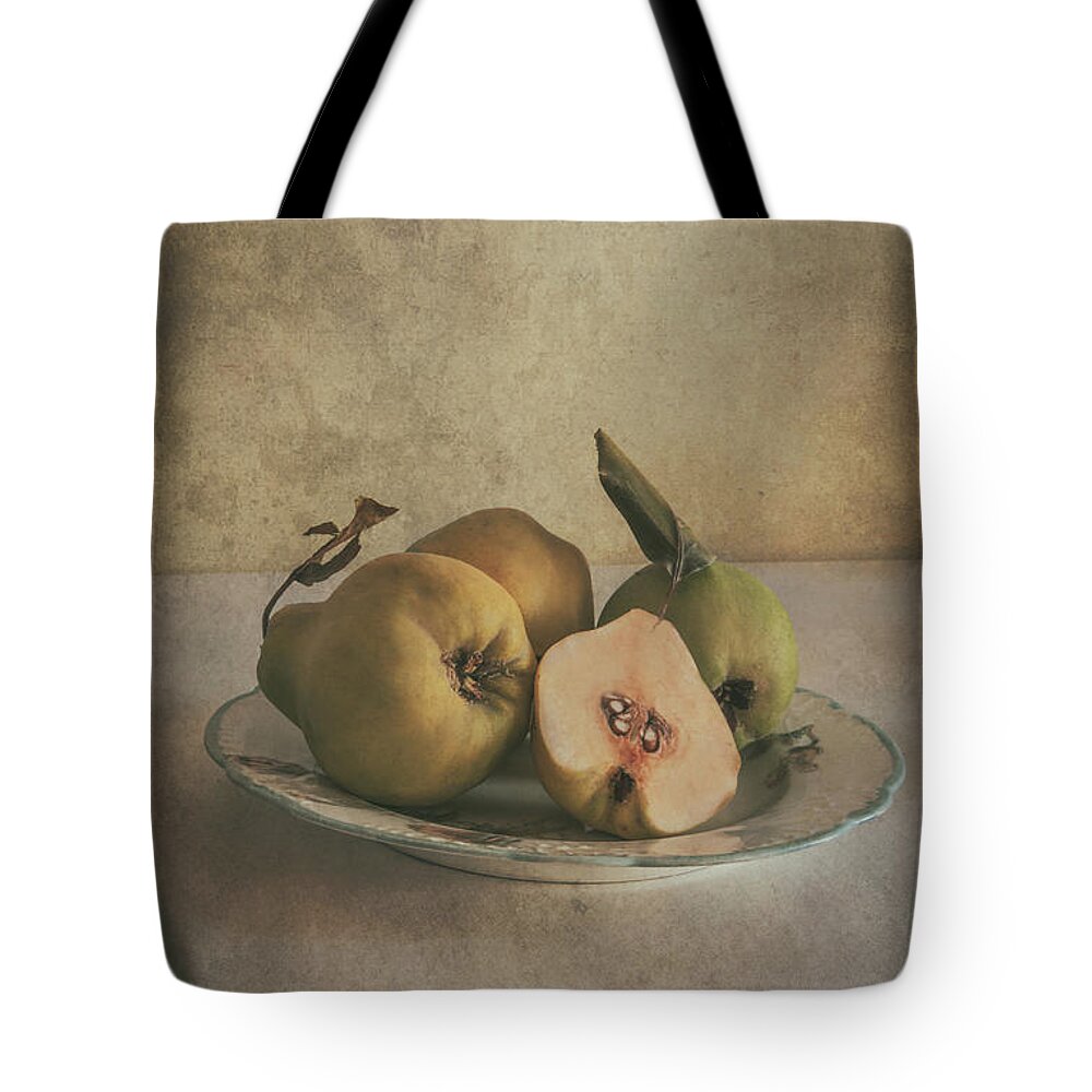 Still Life Tote Bag featuring the photograph Plate of fresh quince by Jaroslaw Blaminsky