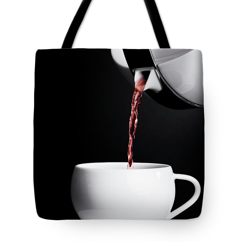 Tea Tote Bag featuring the photograph Pouring tea by Mendelex Photography