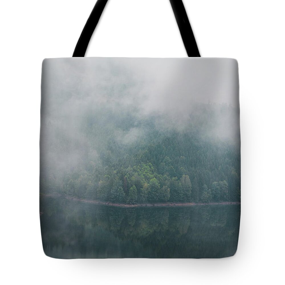 Climate Tote Bag featuring the photograph Rainy and foggy morning at the Sance Dam. Reflection of deciduous forest on the water surface. Autumn weather. Beskydy mountains, Czech republic. Green colour by Vaclav Sonnek