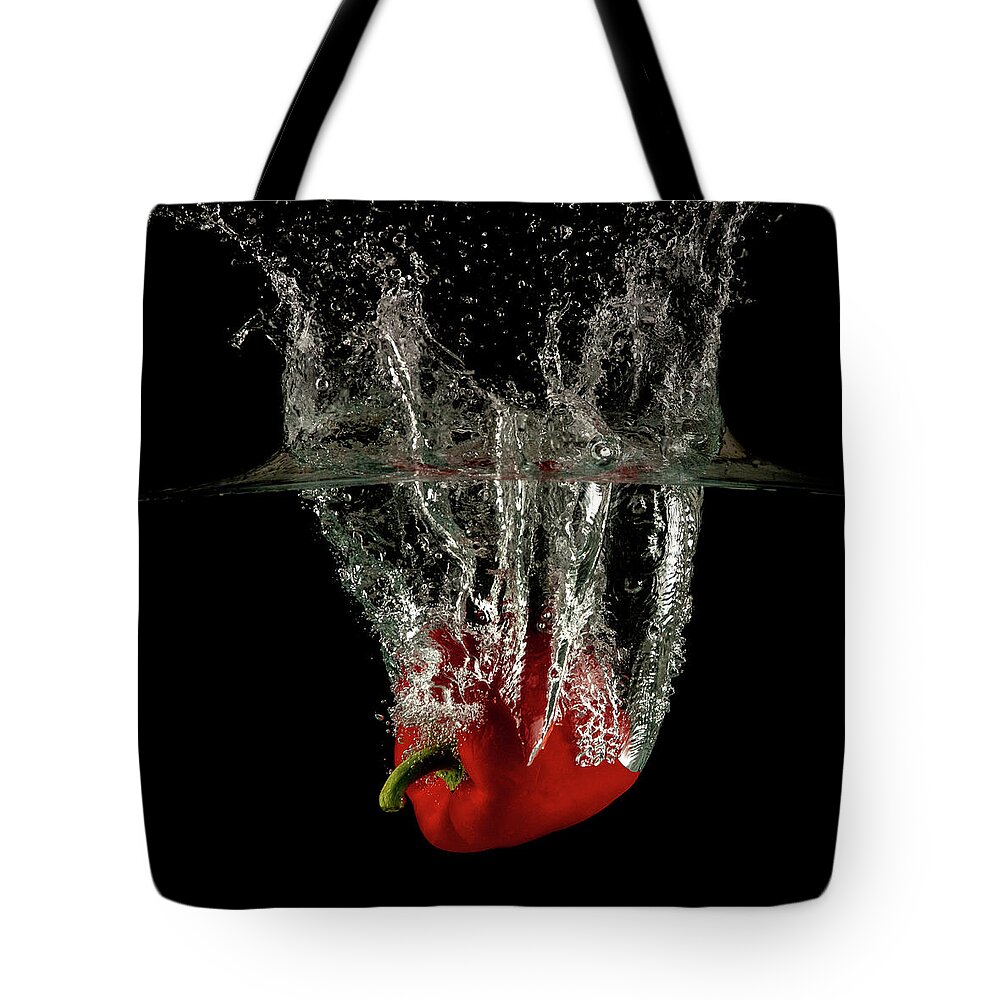 Pepper Tote Bag featuring the photograph Red bell pepper dropped and slashing on water by Michalakis Ppalis