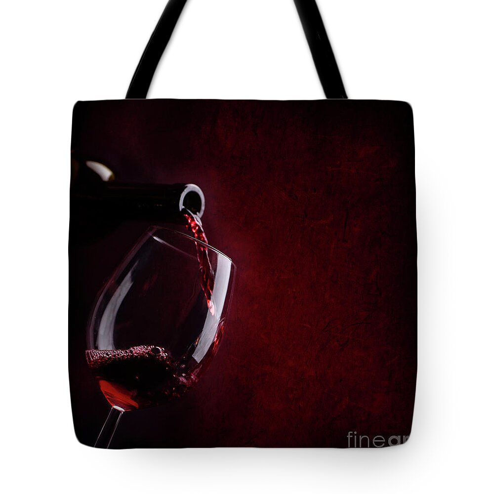 Wine Tote Bag featuring the photograph Red wine pouring in wineglass by Jelena Jovanovic