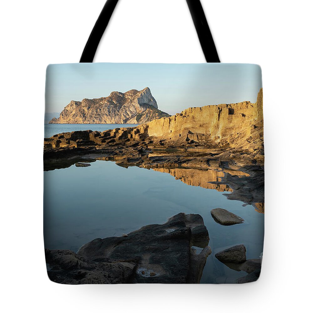 Mediterranean Tote Bag featuring the photograph Reflection of rocks in the calm Mediterranean Sea at sunrise 1 by Adriana Mueller