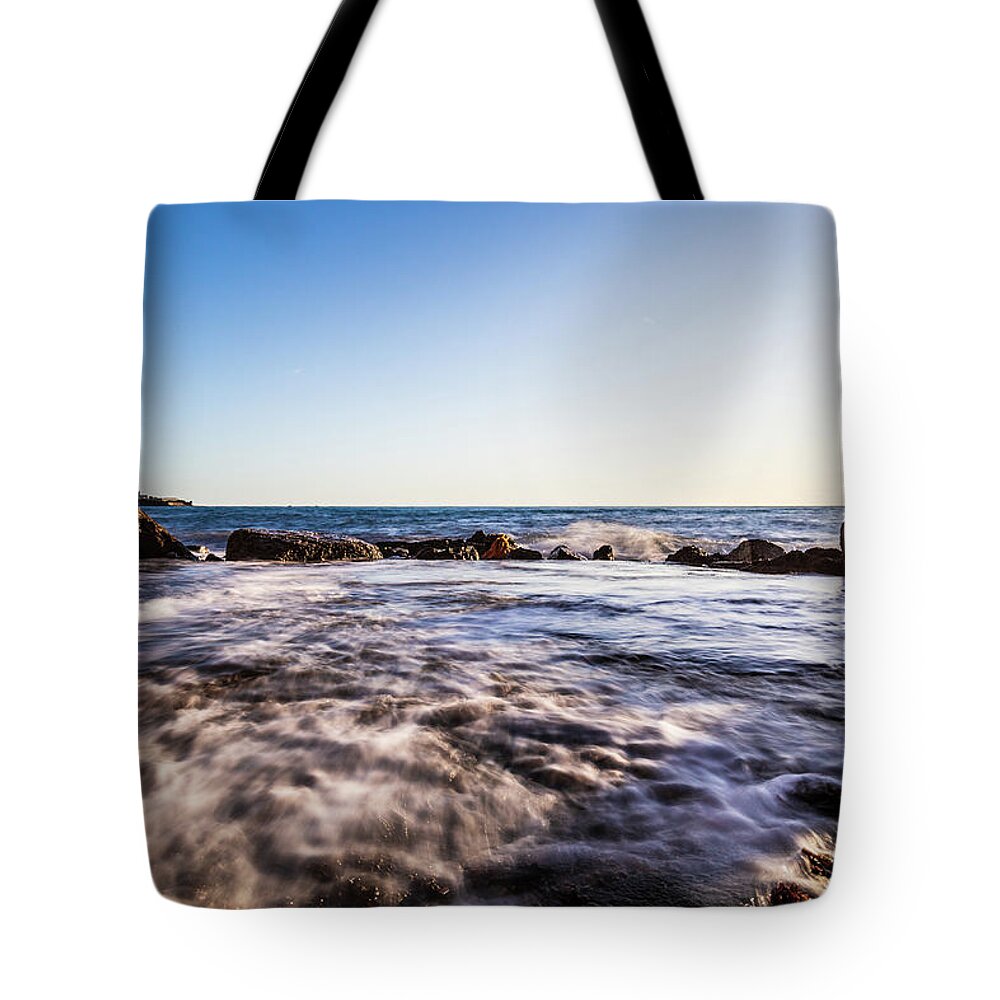 Beach Tote Bag featuring the photograph Seascape at sunset with waves by Fabiano Di Paolo