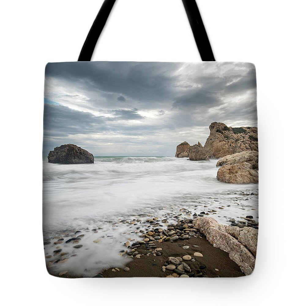 Seascape Tote Bag featuring the photograph Seascape with windy waves splashing at the rocky coastal area. by Michalakis Ppalis
