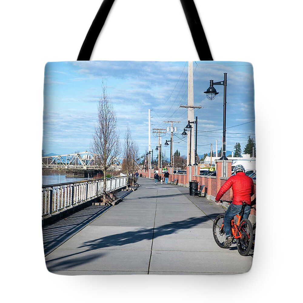 Skagit Riverwalk And Two Cyclists Tote Bag featuring the photograph Skagit Riverwalk and Two Cyclists by Tom Cochran