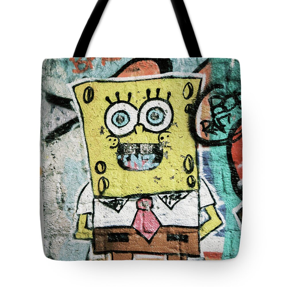 Sponge Tote Bag featuring the photograph Sponge Bob stuck on the wall by Barthelemy De Mazenod