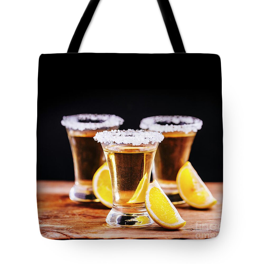 Tequila Tote Bag featuring the photograph Tree shot glasses of Mexican tequila cocktail with lemon slices by Jelena Jovanovic