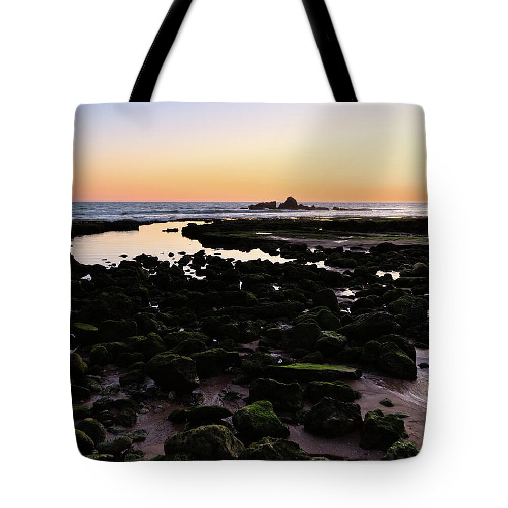 Low Tide Tote Bag featuring the photograph Twilight and rocks in Gale beach by Angelo DeVal