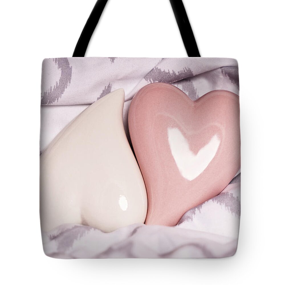 Love Tote Bag featuring the photograph Two red hearts on a modern bedsheet by Mendelex Photography