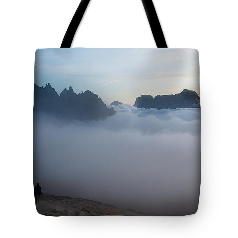 Italian Alps Tote Bag featuring the photograph Unrecognized man trekking at the hiking path at Tre Cime in South Tyrol in Italy. by Michalakis Ppalis