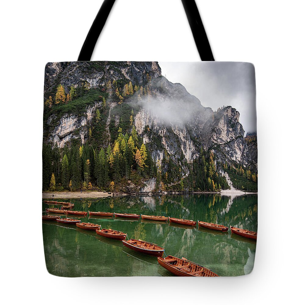Lago Di Braies Tote Bag featuring the photograph Wooden boats on the peaceful lake. Lago di braies, Italy by Michalakis Ppalis