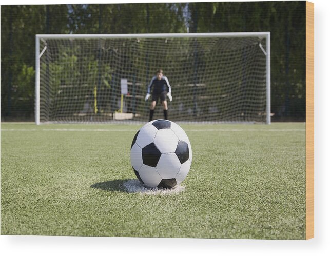 Grass Wood Print featuring the photograph A soccer ball on a soccer field by Caspar Benson