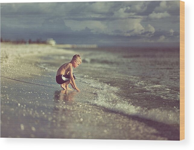 Water's Edge Wood Print featuring the photograph Boy Crouching In Sand Before The Gulf by Rebecca Nelson
