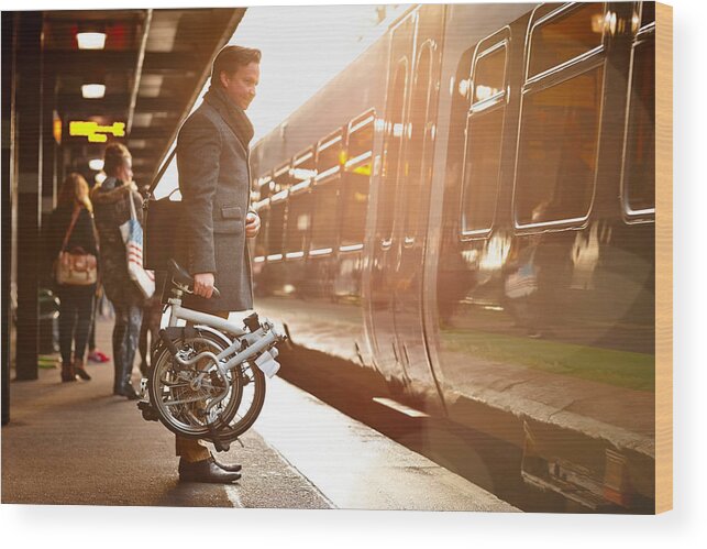 People Wood Print featuring the photograph Businessman with folding cycle boarding train by Dean Mitchell