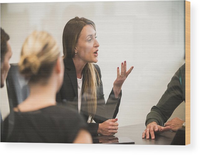 Staff Meeting Wood Print featuring the photograph Businesswoman talking in boardroom meeting. by Stevecoleimages