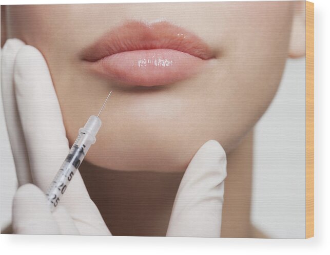 People Wood Print featuring the photograph Close up of woman receiving botox injection in lips by Robert Daly