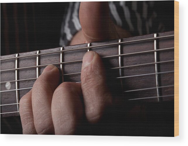 Age Wood Print featuring the photograph Close up shot of a mans left hand playing guitar by Kyle Lee