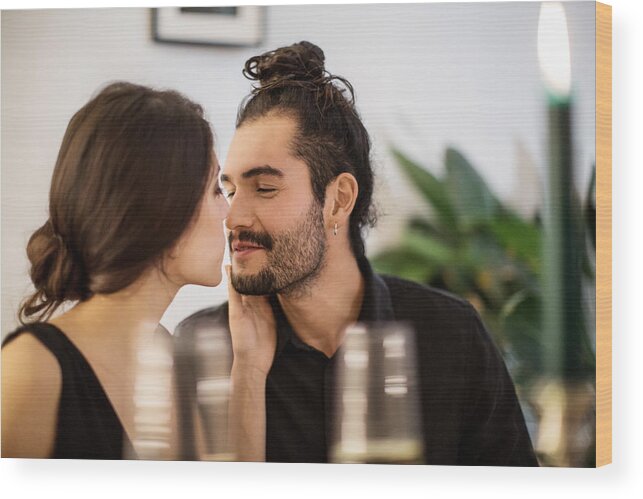 Young Men Wood Print featuring the photograph Couple kissing during dinner party at home by Luis Alvarez