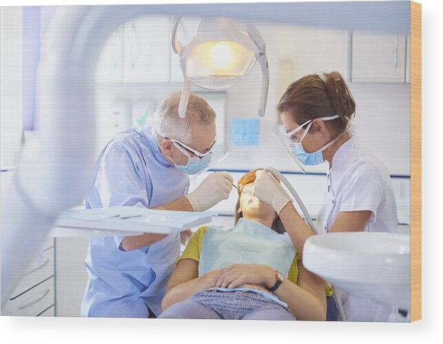 Working Wood Print featuring the photograph Dental team performing procedure by Sturti