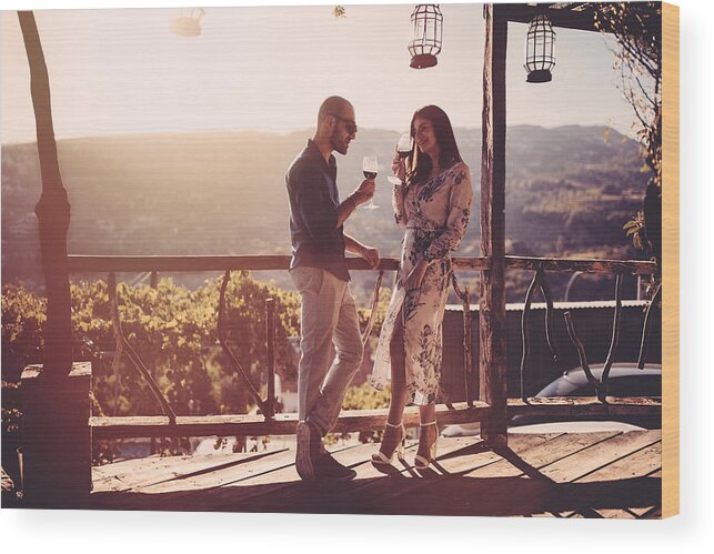 Scenics Wood Print featuring the photograph Elegant couple drinking red wine at French rustic vineyard winery by Wundervisuals