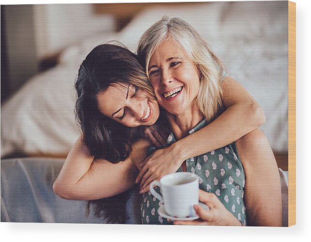 Mature Adult Wood Print featuring the photograph Loving adult daughter embracing cheerful senior mother at home by Wundervisuals