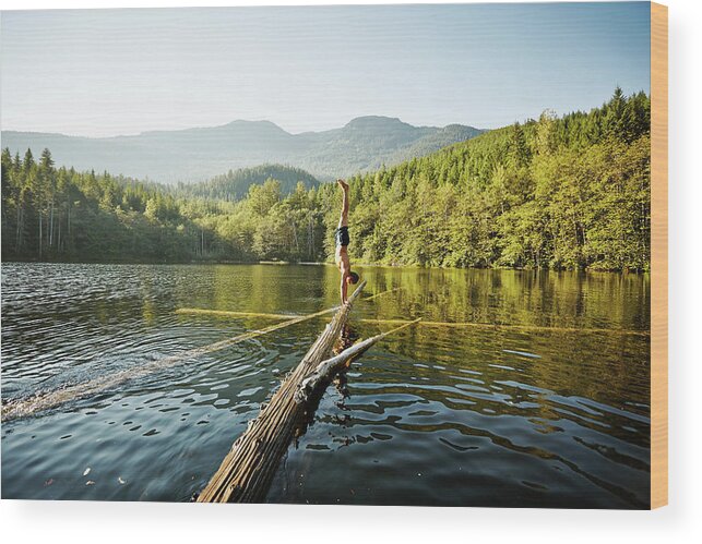 Scenics Wood Print featuring the photograph Man Doing Handstand On Log In Alpine by Thomas Barwick