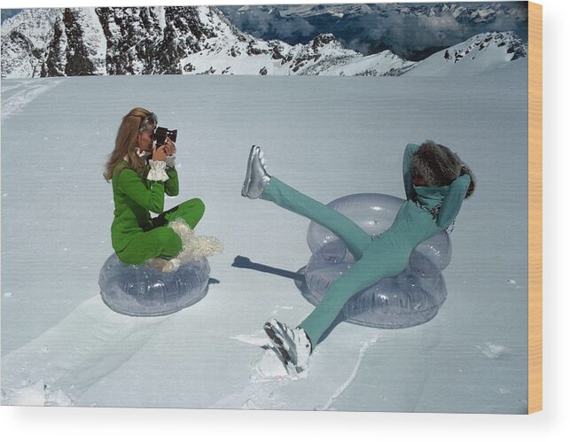 Fashion Wood Print featuring the photograph Models On Plastic Chairs With Snow In Switzerland by Arnaud de Rosnay