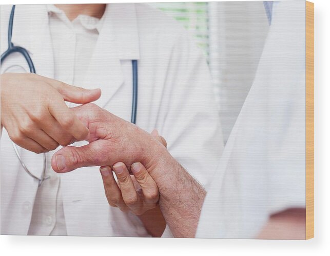 30-34 Years Wood Print featuring the photograph Nurse Checking Man's Hand Joints by Science Photo Library