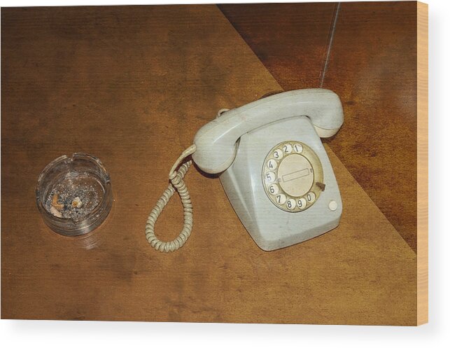 Phone Wood Print featuring the photograph Old telephone and ashtray on brown table by Matthias Hauser