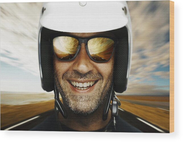 Crash Helmet Wood Print featuring the photograph Photograph of a happy male biker smiling with sky backdrop by Mikkaphoto