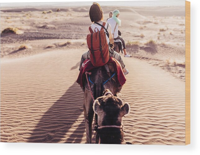 Scenics Wood Print featuring the photograph Rear view of people riding camels in desert by Oscar Wong
