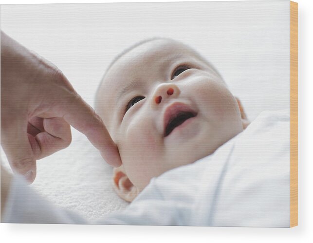 Mature Adult Wood Print featuring the photograph Smiling baby with finger of father,close up by Sot