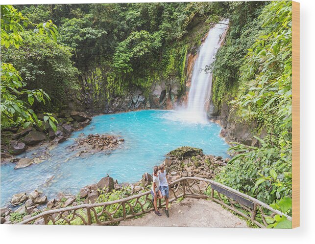 Young Men Wood Print featuring the photograph Tourist couple looking at Rio Celeste waterfall by Matteo Colombo