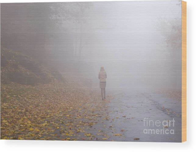 Woman Wood Print featuring the photograph Walking on a foggy road by Mats Silvan