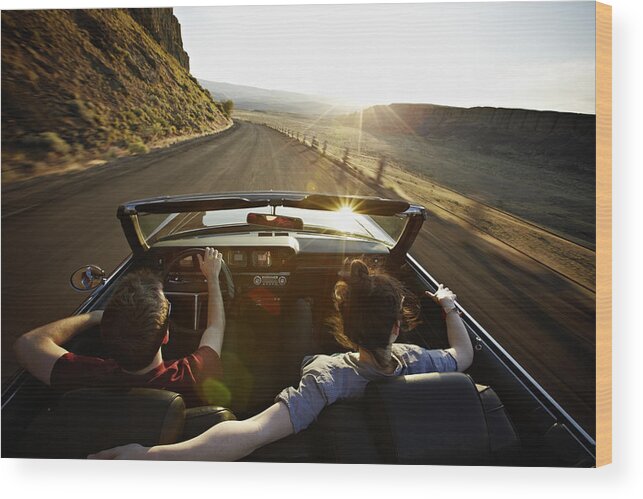 Young Men Wood Print featuring the photograph Young couple driving convertible at sunset by Thomas Barwick