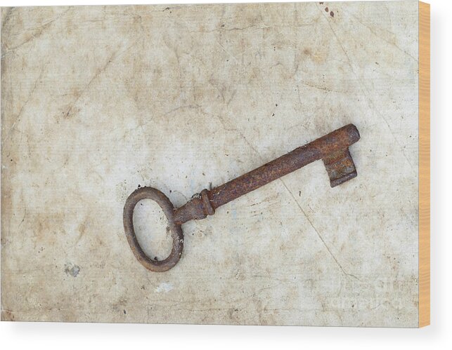 Key Wood Print featuring the photograph Rusty key on old parchment #1 by Michal Boubin