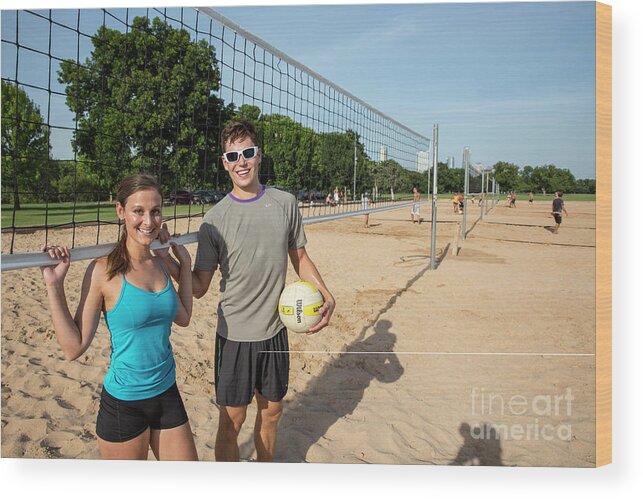 Zilker Park Beach Volleyball Courts Wood Print featuring the photograph Young fit couple on the at the Zilker Park sand volleyball courts with volleyball on sunny summers day #2 by Dan Herron