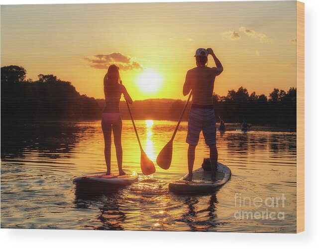 Silhouette Wood Print featuring the photograph A silhouette of a couple on a stand-up paddle boards SUP at sunset on Lady Bird Lake in Austin Texas by Dan Herron