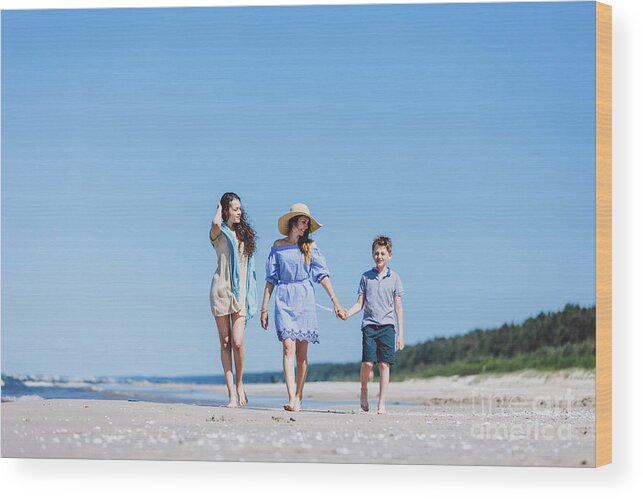 Family Wood Print featuring the photograph Mother and her two children walking on the beach by Michal Bednarek