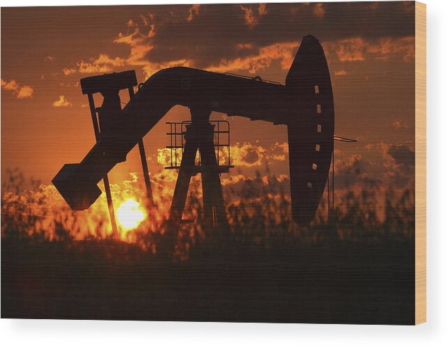 Oil Rig Wood Print featuring the photograph Oil rig pump jack silhouetted by setting sun by Mark Duffy