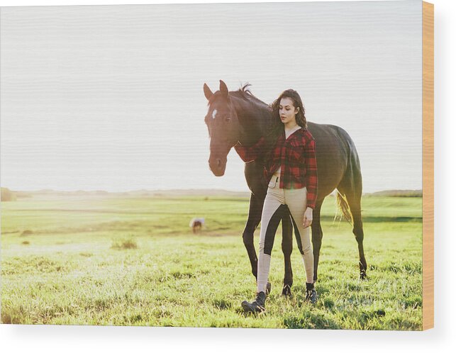 Woman Wood Print featuring the photograph Young woman standing next to her black horse by Michal Bednarek