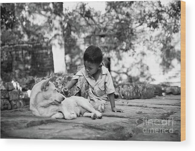 2015 Wood Print featuring the photograph Cambodian boy near some ruins playing with his dog. #1 by Joaquin Corbalan