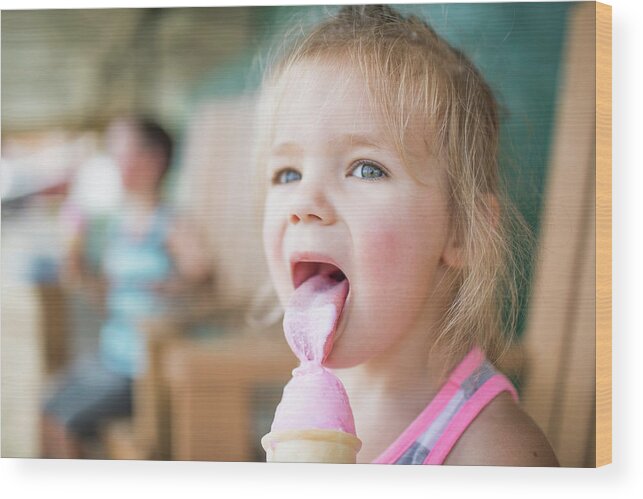 Young Cute Girl Happily Licking Pink Ice Cream On Summer Day Wood