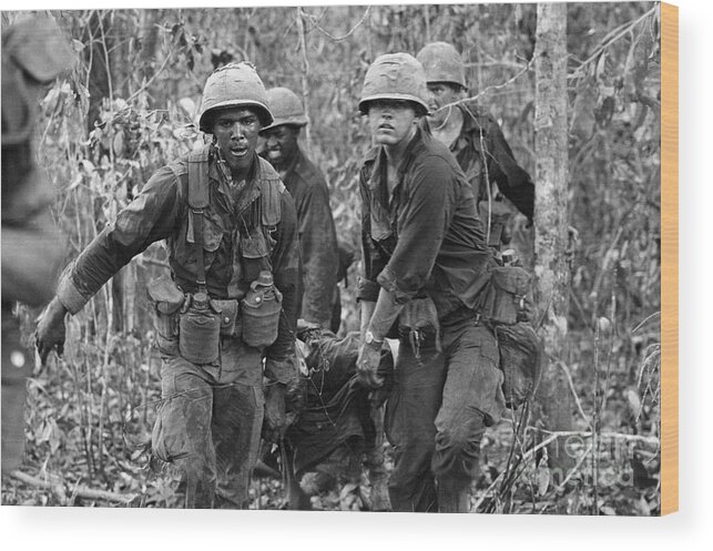 Vietnam War Wood Print featuring the photograph Carrying Wounded Comrade by Bettmann