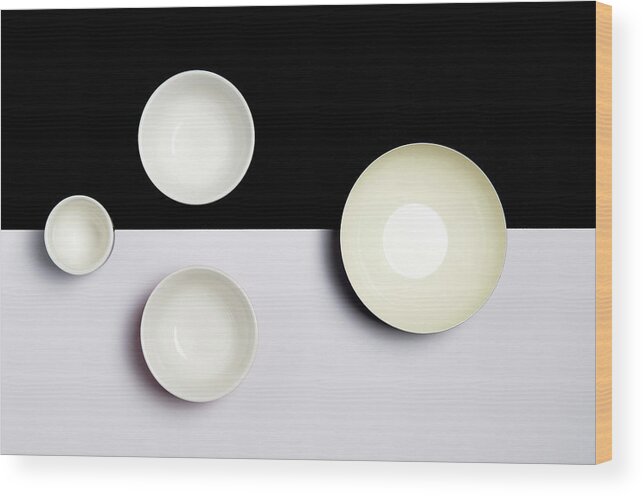 Still-life Wood Print featuring the photograph Group of empty ceramic bowls of on a black and white surface by Michalakis Ppalis