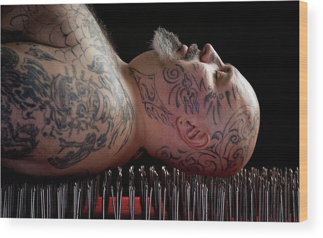 Tranquility Wood Print featuring the photograph Man Lying On A Bed Of Nails by David Sacks