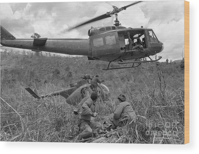 Helicopter Crash Wood Print featuring the photograph Soldiers Recovering Grounded Helicopter by Bettmann