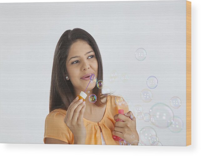 People Wood Print featuring the photograph Young woman blowing soap bubbles #1 by Ravi Ranjan