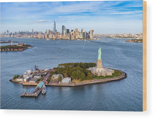 Lower Manhattan Wood Print featuring the photograph aerial view of the statue Liberty island in front of Manhattan skyline. New York. USA by Eloi_Omella