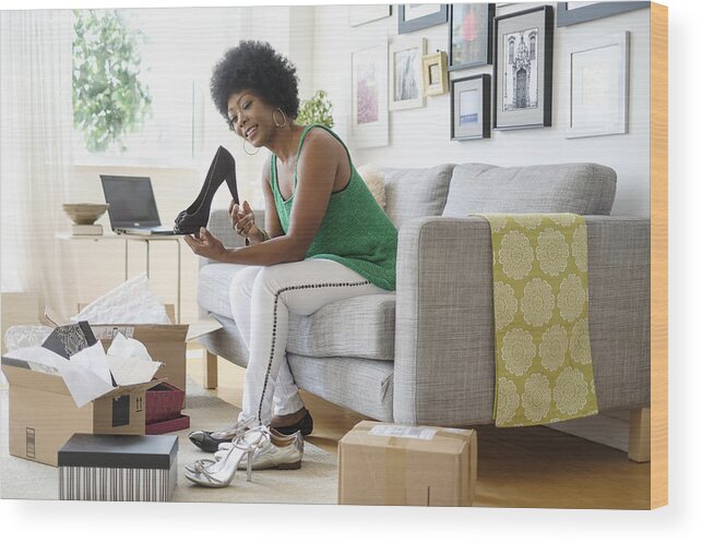 Internet Wood Print featuring the photograph African American woman opening packages of shoes on sofa by JGI/Tom Grill
